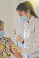 Injection of the vaccine against the covid-19 by a doctor and a nurse in a vaccination center