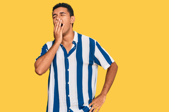 Young arab man wearing casual clothes bored yawning tired covering mouth with hand. restless and sleepiness.