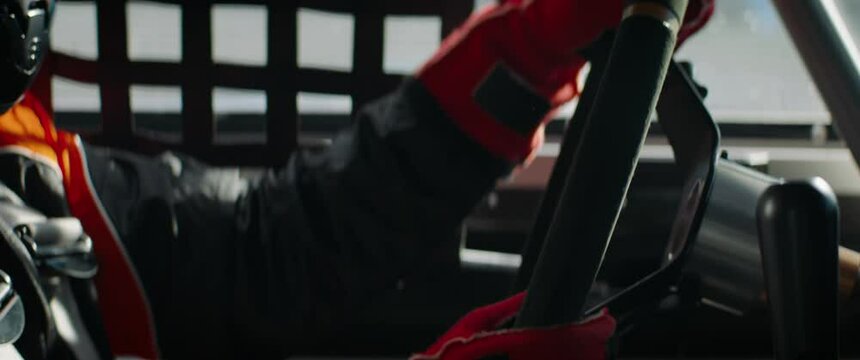 CU on hands and steering wheel, sports car driver in racing on a speedway. Fast speed, motorsport. Daytime shot. Shot with 2x anamorphic lens