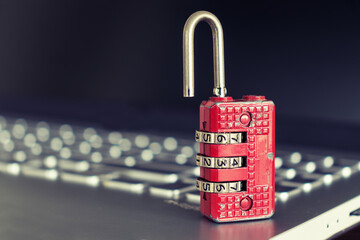 Red ruined padlock on a laptop keyboard. Computer security concept. Copy space.