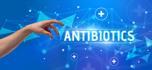 Close-Up of cropped hand pointing at ANTIBIOTICS inscription, medical concept