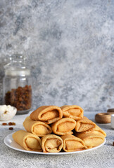 Thin spring rolls on a light concrete background. Platbands. National, traditional dish of Belarus and Ukraine. Pancakes