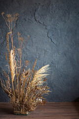 dried flowers against a gray textured wall
