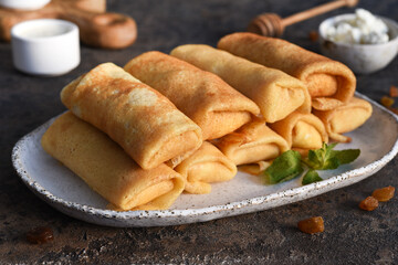 Thin pancakes with cottage cheese on a dark concrete background. Platbands. National, traditional dish of Belarus and Ukraine.