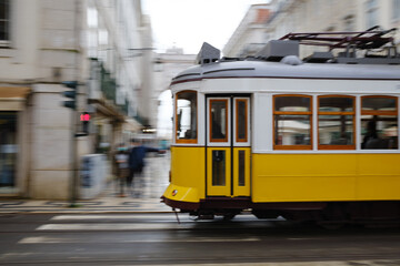 Fototapeta na wymiar The typical yellow tram through the streets of Lisbon, Portugal