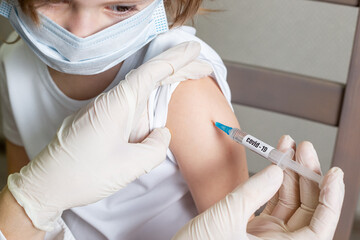 Doctor holding syringe with Covid-19 or coronavirus vaccine.