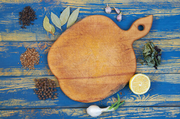 Brown board with copy space decorated with spices and herbs. Top view of spices texture background