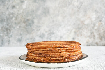 Stack of pancakes on the breakfast plate on a light background. Pancakes in the morning for breakfast.