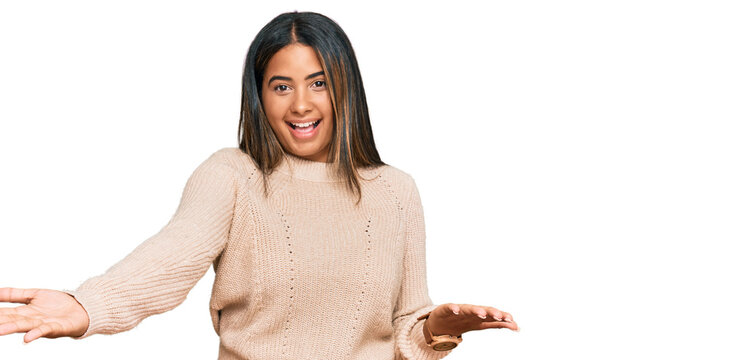 Young latin girl wearing wool winter sweater smiling cheerful offering hands giving assistance and acceptance.