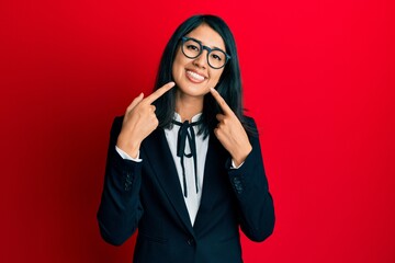 Beautiful asian young woman wearing business suit smiling cheerful showing and pointing with fingers teeth and mouth. dental health concept.