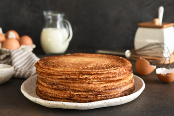 Stack of pancakes on the plate for breakfast. Pancake ingredients: milk, eggs, flour. Thin pancakes. Good morning.