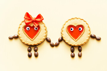 Loving couple made of jelly heart cookies and coffee beans holding hands. Creative Valentine's Day concept.