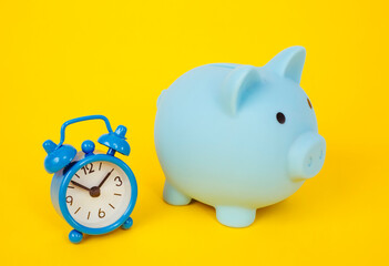 a piggy bank. moneybox and clock on a yellow background.