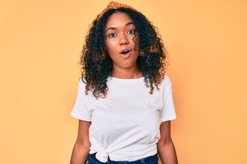 Young african american woman wearing casual clothes scared and amazed with open mouth for surprise,...