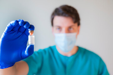 male doctor with covid vaccine in hand. Vaccination and immunization