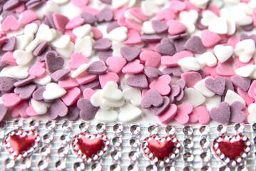 Delicious pink Valentine's Day sugar hearts and ornaments in pink, purple and white show I love you to your girlfriend and beloved people with precious diamonds and red hearts jewelry as special gift