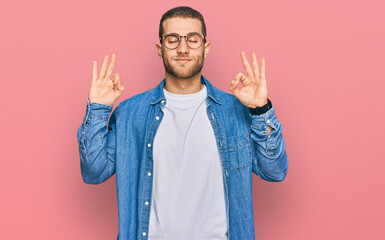Young caucasian man wearing casual clothes relaxed and smiling with eyes closed doing meditation gesture with fingers. yoga concept.