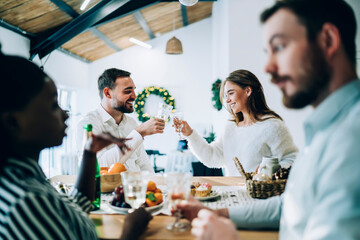 Friends clinking champagne glasses at Christmas party