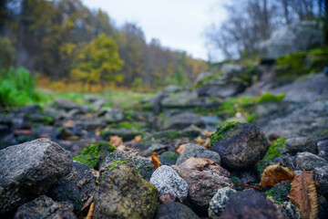 Stones stacked in a hill near the stream. Round stones. granite