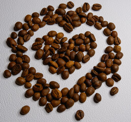 Drawing heart with coffee beans on a white background