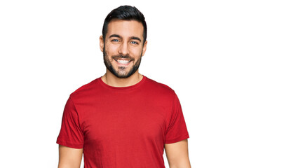 Obraz premium Young hispanic man wearing casual clothes looking positive and happy standing and smiling with a confident smile showing teeth