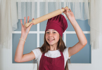 Feed your dreams. choosing a career. little helper use rolling pin. culinary and cuisine. happy childhood. happy child wear cook uniform. chef girl in hat and apron. kid cooking food in kitchen