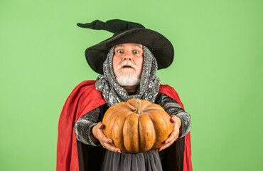 give it to you. gothic man in Halloween costume. senior man hold pumpkin. old man in magic hat and cloak. Jack-o-lantern. Fantasy horror Halloween. Halloween decoration and scary concept. 31 october