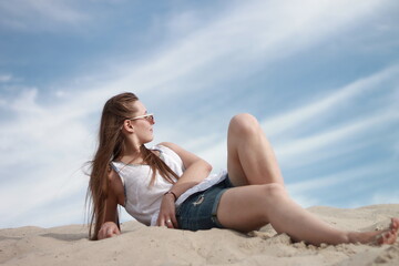 Fototapeta na wymiar girl on the beach against the blue sky