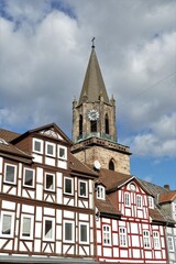 Fototapeta na wymiar Kirchturm der Stiftskirche mit Fachwerkhäuser in Rotenburg a.d. Fulda