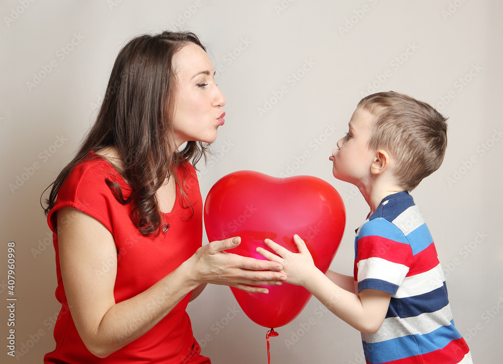 Wall mural son loves mom and gives her a red hot air balloon in the shape of a heart. valentine's day. mothers 