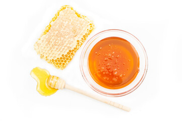 Piece of honeycomb, organic fresh liquid honey with dipper isolated on white background, healthy food