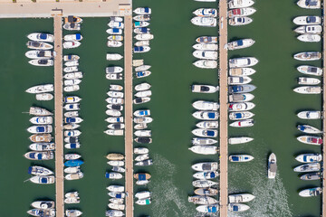 Top straight down aerial drone photo of the beautiful island of Ibiza in Spain showing the boating harbour with rows of speed and sail boats in the harbour on a bright sunny summers day
