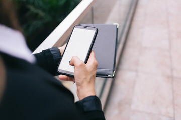 Anonymous woman browsing smartphone on balcony