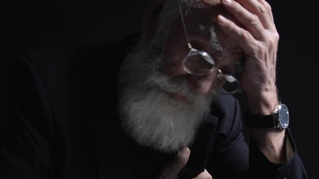 Mature male director with grey beard feeling heart ache, symptom of infarction