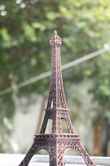 miniature eiffel tower and a tree in the background