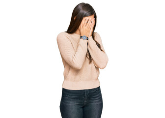 Young brunette woman wearing casual winter sweater with sad expression covering face with hands while crying. depression concept.