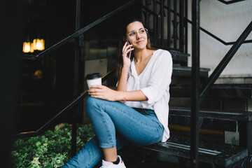 Happy young woman on stairs chatting on phone