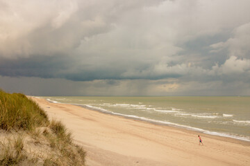 Personne seule sur une plage avec une tempête, un orage au dessus de la mer