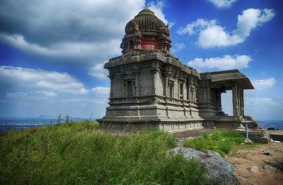 Historical and ancient temple on a hill under the cloudy blue sky in India