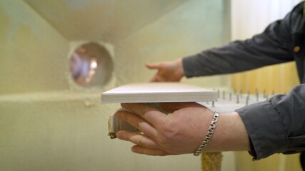 The master applies the glue with a glue gun. Applying glue to a wooden product.