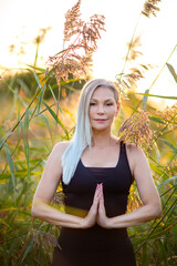 Weißhaarige grauhaarige Frau macht Yoga im freien 50+
