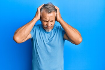 Fototapeta premium Middle age grey-haired man wearing casual clothes suffering from headache desperate and stressed because pain and migraine. hands on head.