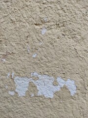 Texture. Wallpaper. Old rough wall painted yellow with chipping. Vintage