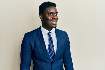 Handsome black man wearing business suit and tie looking to side, relax profile pose with natural face and confident smile.