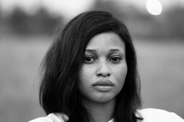 black and white portrait of a beautiful young african woman, close up on her face which has freckles