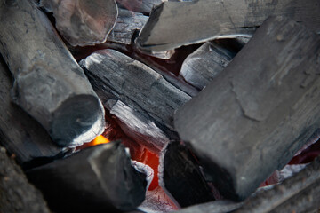 Close up of brightly burning wooden logs with yellow hot flames of fire..