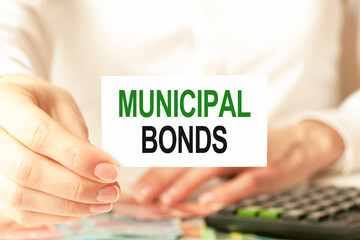 Business concept. Businesswoman shows a card with the text MUNICIPAL BONDS