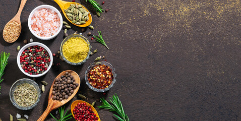 Assortment of natural organic aromatic spices and herbs on dark stone rustic background. Spices...