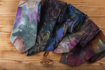 close-up view, many multi-colored folded, intertwined ties, sloping horizon. Textured background of classic fabrics