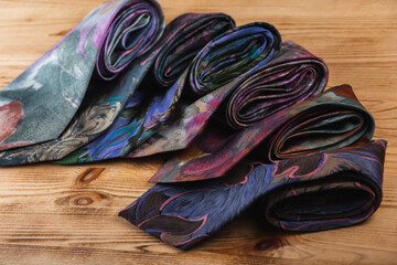 close-up view, many multi-colored folded, intertwined ties, sloping horizon. Textured background of classic fabrics